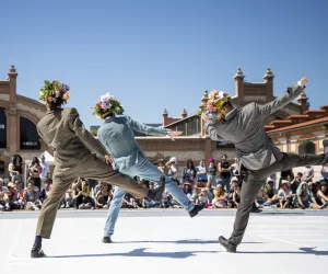 Three dancers perform with their backs turned