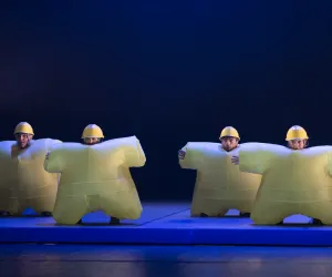 Four dancers wearing inflatable yellow costumes.